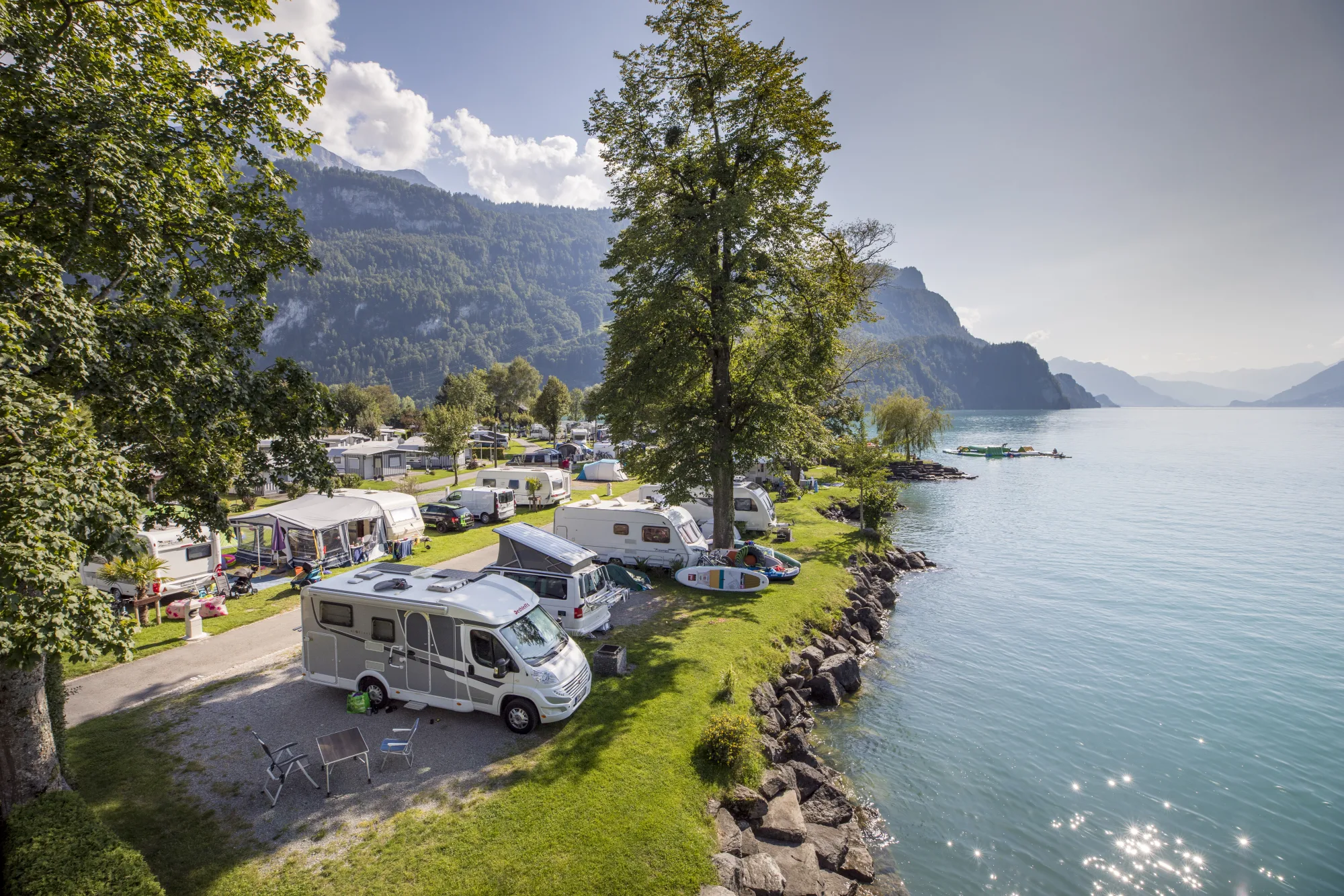 Reisemobile und Wohnwagen auf Seeparzellen direkt am Brienzersee mit Alpenkulisse